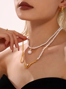 Detailed close-up of French baroque pearl necklace with elegant gold U-shaped earrings