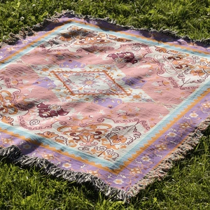 Close-up of bohemian woven camping blanket with geometric patterns and fringe edges