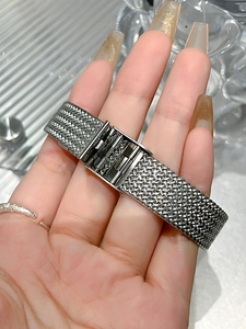 Detailed macro view of the silver mesh steel watch band and its folding security clasp