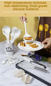 White silicone kitchen utensil set with marble holder on a countertop setting