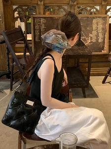 Close-up of black quilted cloud bag with signature white numeric label in a vintage setting