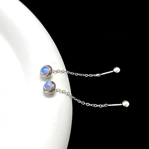 Detail of silver titanium steel earrings with iridescent moonstone and long chain tassels