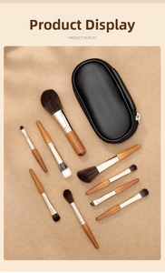 Detail shot of 8 mini makeup brushes with natural wood handles and a black zipper pouch
