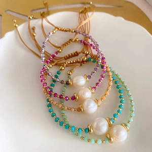 Detailed macro of bohemian beaded friendship bracelets with natural pearls and golden discs