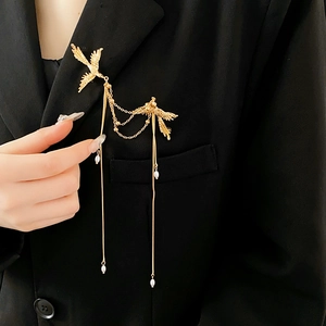 Detailed close-up of a Phoenix pearl tassel brooch pinned on a black suit lapel