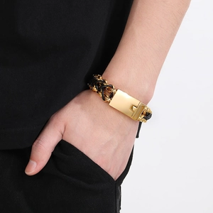 Detailed close-up of woven leather bracelet with polished golden stainless steel clasp
