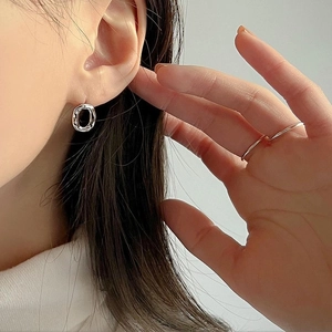 Detailed close-up of 925 sterling silver irregular hammered texture hoop earrings on model