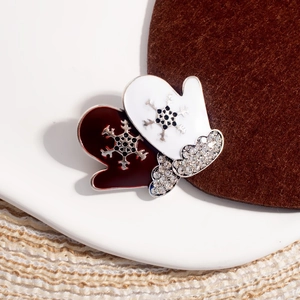Macro detail of Christmas glove brooches with silver snowflakes and white rhinestones