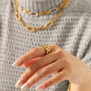 Detailansicht eines goldfarbenen Edelstahlrings mit Herzstruktur und Zirkonia-Akzenten