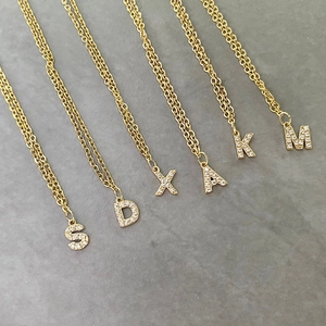 Detail of 14K gold plated initial pendants with sparkling zircon pavé on O-shaped chains