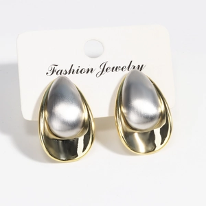 Detailed view of two-tone gold and silver brushed metal teardrop stud earrings