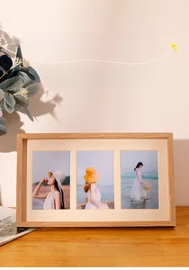 Detailed view of natural wood triple picture frame with beige mats on a wooden desk
