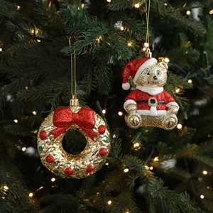 Golden Christmas tree ornaments featuring a teddy bear and festive bow wreath with glitter
