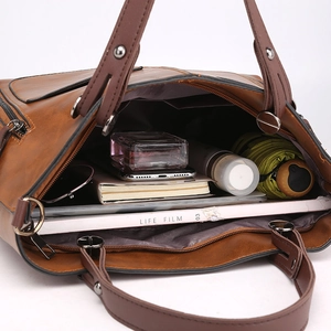 Brown PU leather tote bag with dual handles and large capacity shown in a studio setting