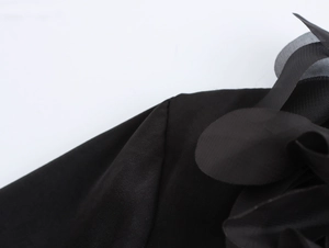 Detailed macro shot of elegant black satin fabric and sheer organza texture for blouses