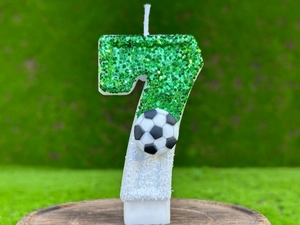 Macro d'une bougie d'anniversaire foot numéro 7 à paillettes vertes avec mini ballon
