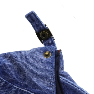 Macro shot of bronze star buckle and adjustable strap on dark blue denim flat cap