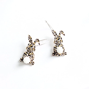 Detailed view of leopard print bunny earrings with a soft white pompom tail charm