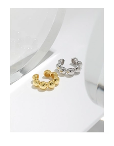 Detailed view of silver and gold geometric bead ear cuffs on a clean white background