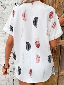 Detail shot of white short sleeve shirt featuring a vibrant red and black feather print back