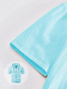 Detail shot of light blue cotton linen fabric texture on short sleeve hooded shirt