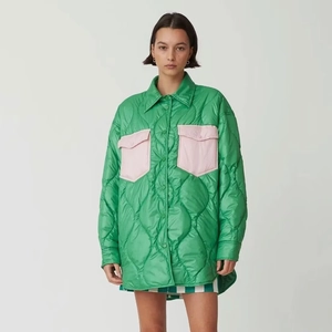 Dettaglio della giacca trapuntata verde con tasche rosa a contrasto e trama