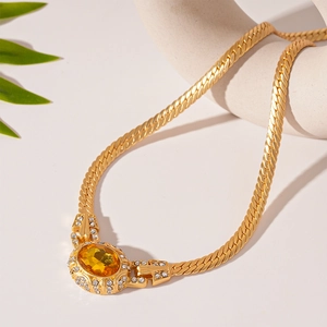 Macro detail of vintage gold chain necklace with oval yellow gemstone and crystal border