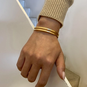 Detailed shot of double-layer 18k gold plated stainless steel cuff bracelet on model wrist