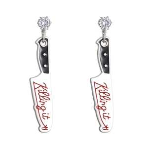 Macro shot of cleaver shaped earrings with Killing It script and zircon stones
