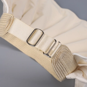 Detail of adjustable elastic band and silver metal buckle on a satin jacquard sun hat