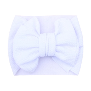 Detailed view of a white textured fabric baby headband featuring a large soft bow