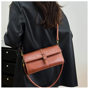 Dettaglio della borsa a tracolla vintage in pelle marrone con tracolla regolabile e fibbie