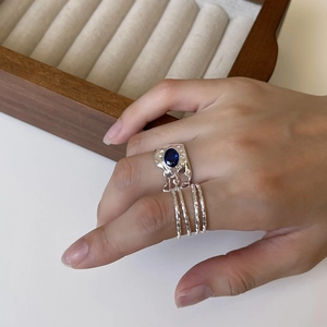 Detailed view of an S925 silver multi-layer ring featuring an oval blue gemstone on a finger