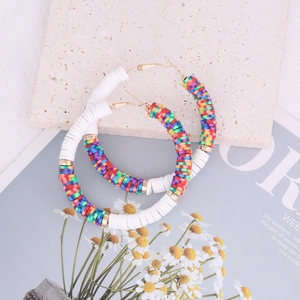 Detail of bohemian round hoop earrings featuring colorful rainbow polymer clay clay discs