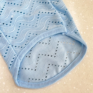 Detail of light blue dog clothes featuring wavy hollow-out knit fabric and neat stitching