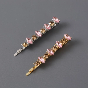 Macro view of gold and silver barrettes with pink and brown marquise rhinestones