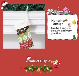 Detail of red and green knitted Christmas stocking with hanging loop and snowflake patterns