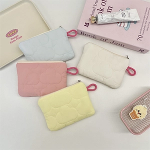 Detailed top view of colorful quilted cloud pouches for coins and earphones storage