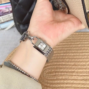 Close-up of a silver square watch for women with a metallic chain strap and matching bracelet