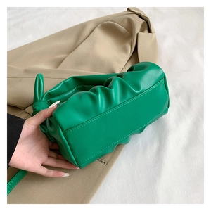 Close-up of green ruched cloud bag showing bottom stitching and soft leather texture