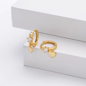 Detail of 18K gold-plated heart drop earrings with sparkling cubic zirconia inlay