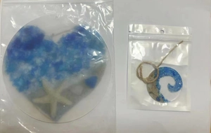 Detail of beach sea glass suncatchers with starfish and sand in resin packaging