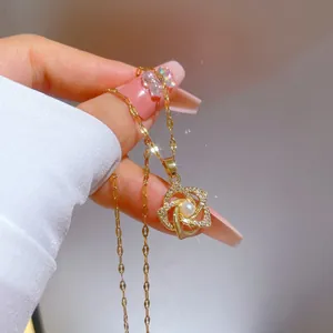 Macro detail of gold-plated rotating flower pendant with sparkling zircons and a pearl