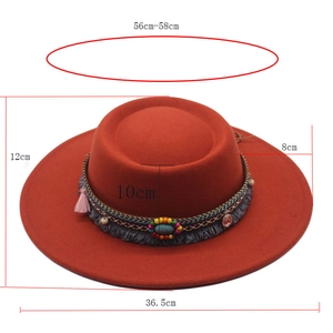 Detail view of brick red flat top felt hat with ethnic beads and tassel decorations