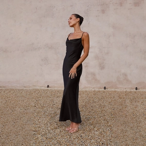 Detail of slim straps and backless design on a black satin maxi dress for women
