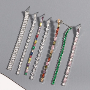 Macro detail of various zircon tassel earrings showing silver settings and colorful gems