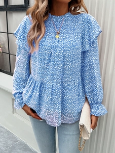 Detail of blue floral print blouse with ruffled cuffs and elegant stand collar design