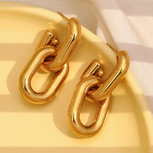 Detailed close-up of 18K gold-plated hollow chain link earrings on a ceramic dish