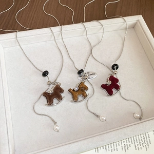Detailed macro view of rocking horse necklaces in flocking and marble textures on silver chains