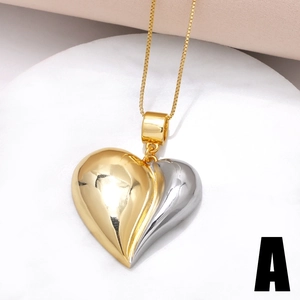 Two-tone gold and silver heart pendant necklace with zircon inlay on a white stone tray